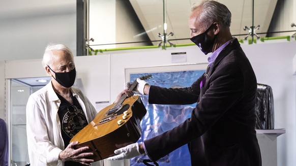 epa08487467 Voltage Guitars&#039; Lloyd Chiate (L), who sold the &#039;MTV Unplugged in New York&#039; guitar to Kurt Cobain, holds the guitar on display while talking to the auctioneer at the Julien& ...