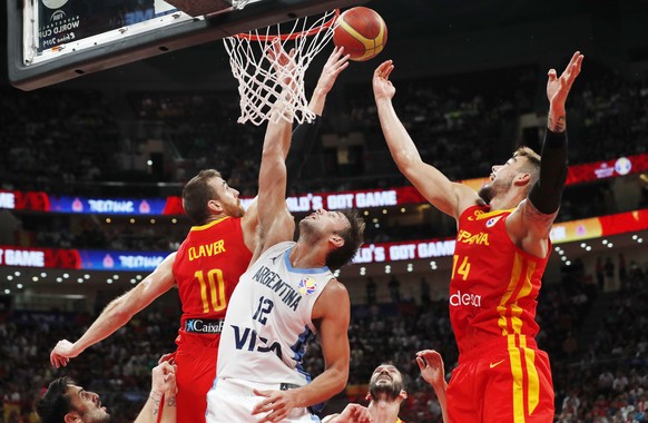 epa07844347 Victor Claver (L) and Willy Hernangomez Geuer (R) of Spain in action against Marcos Delia of Argentina during the FIBA Basketball World Cup 2019 final match between Argentina and Spain, in ...