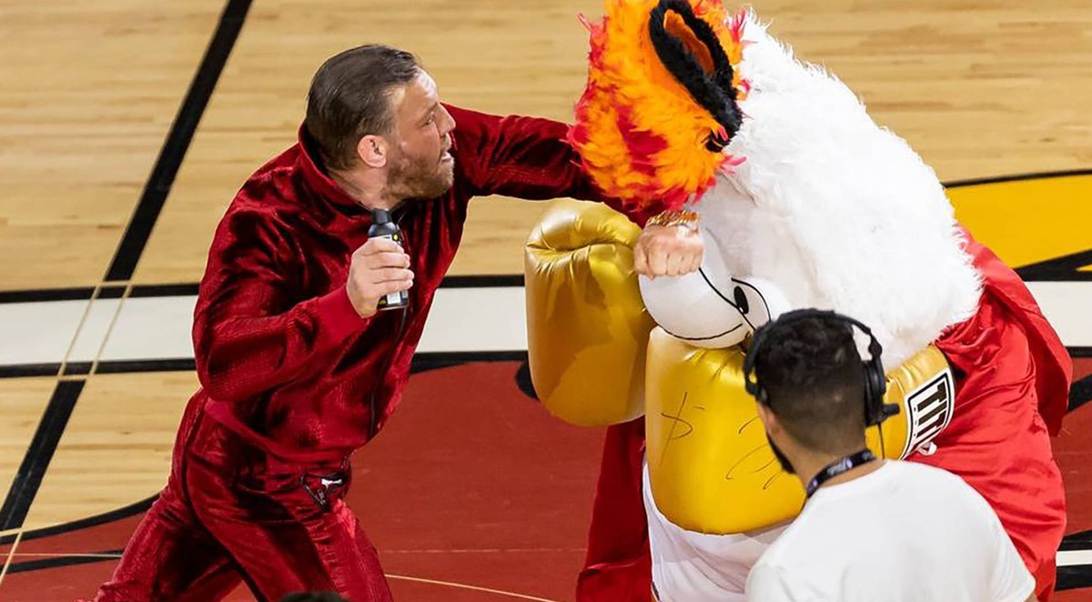 June 9, 2023, Miami, Florida, USA: Mixed martial arts fighter CONOR MCGREGOR, 34, left, swings at Miami Heat mascot Burnie during a timeout period in Game 4 of the NBA, Basketball Herren, USA Finals a ...