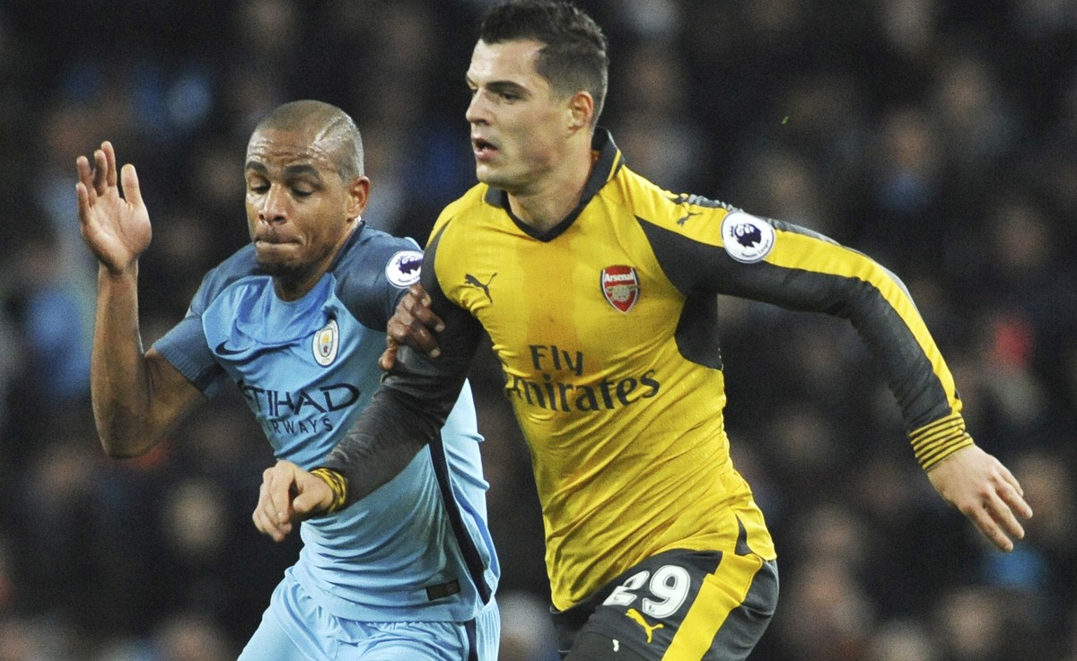 Manchester City's Fernando and Arsenal's Granit Xhaka, right, in action during the English Premier League soccer match between Manchester City and Arsenal at the Etihad Stadium in Manchester ...