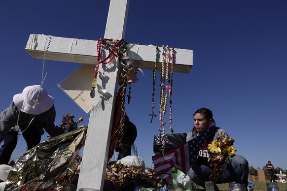 Volunteers Annabelle Andon, left, and Joanna Polk, remove items left at the memorials for the Marjory Stoneman Douglas High School shooting victims, Thursday, March 15, 2018, at Pine Trails Park in Pa ...