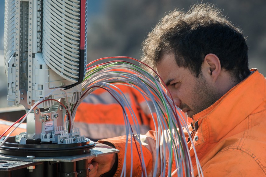 Ein Arbeiter montiert Glasfaserkabel der Swisscom fuer den Internetansschluss von Privathaushalten, am Dienstag, 10. Februar 2015 in Bellinzona. Die staedtischen Betriebe Bellinzona &quot;Aziende Muni ...