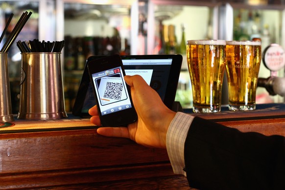 SYDNEY, AUSTRALIA - SEPTEMBER 19: In this photo illustration, a customer scans a QR code to pay for drinks using bitcoins on September 19, 2013 in Sydney, Australia. The Old Fitzroy pub in Sydney&#039 ...