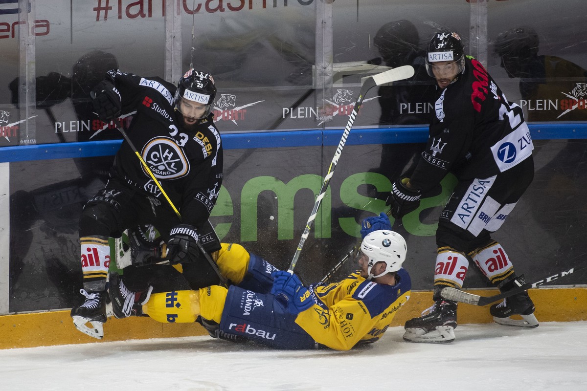 From left, Lugano's player Giovanni Morini, Davos's player Perttu Lindgren and Lugano's player Mauro Joerg, during the preliminary round game of National League Swiss Championship 2018/ ...
