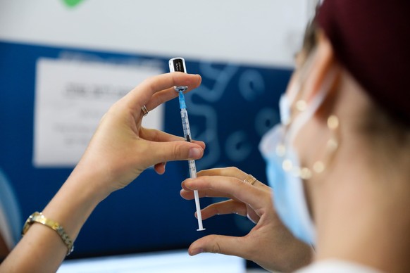 epa09436593 A nurse prepares a shot of COVID-19 vaccine in Jerusalem, Israel, 30 August 2021. Israel launched a campaign to offer a third Covid-19 vaccine dose for people over 30 who received a second ...