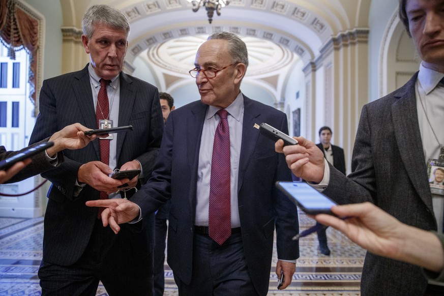 epa08082165 Senate Minority Leader Chuck Schumer responds to a question from the news media as he walks to meet with Speaker of the House Nancy Pelosi in the US Capitol in Washington, DC, USA, 19 Dece ...