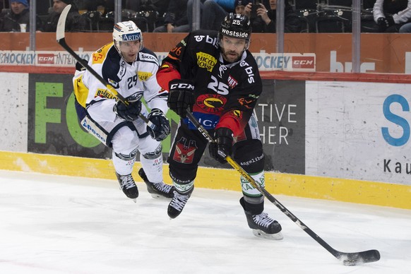 Ambris Michael Fora, links, und Berns Andrew Ebbett, rechts, kaempfen um den Puck, beim Eishockey Meisterschaftsspiel der National League zwischen dem SC Bern und den HC Ambria-Piotta, am Dienstag, 29 ...