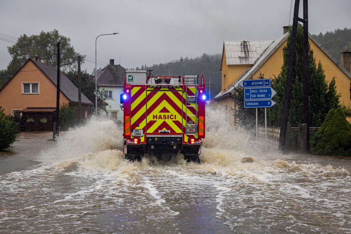 epa11604479 Firefighters vehicle drive during heavy rain throught overfloating Bela river in Mikulovice, Czech Republic, 14 September 2024. The Czech Hydrometeorological Institute (CHMU) has issued a  ...