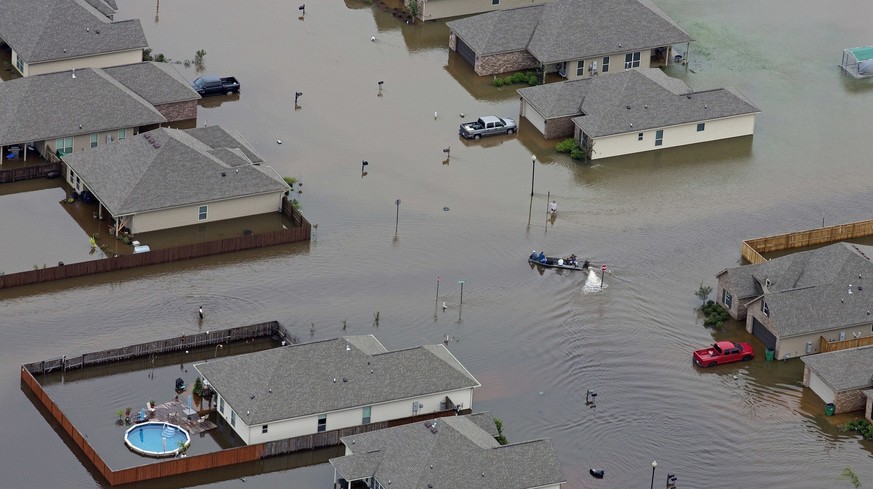 FILE- A boat motors between flooded homes after heavy rains inundating the region, in Hammond, La., on Aug. 13, 2016. A new study Thursday, May 18, 2023, finds the natural burst of El Nino warming tha ...