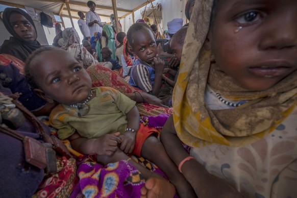 epa11264107 Sudanese refugees sit in a makeshift tent in the Adre transition camp, on the border with Sudan in Adre, Chad, 05 April 2024 (issued 07 April 2024). Since the war in Sudan began, more than ...