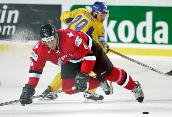 Switzerlands&#039;s Timo Helbling, left, is checked by Ukraine&#039;s Vitaly Semenchenko, during the Ice Hockey World Championship Preliminary round group B match between Switzerland and Ukraine in Ri ...