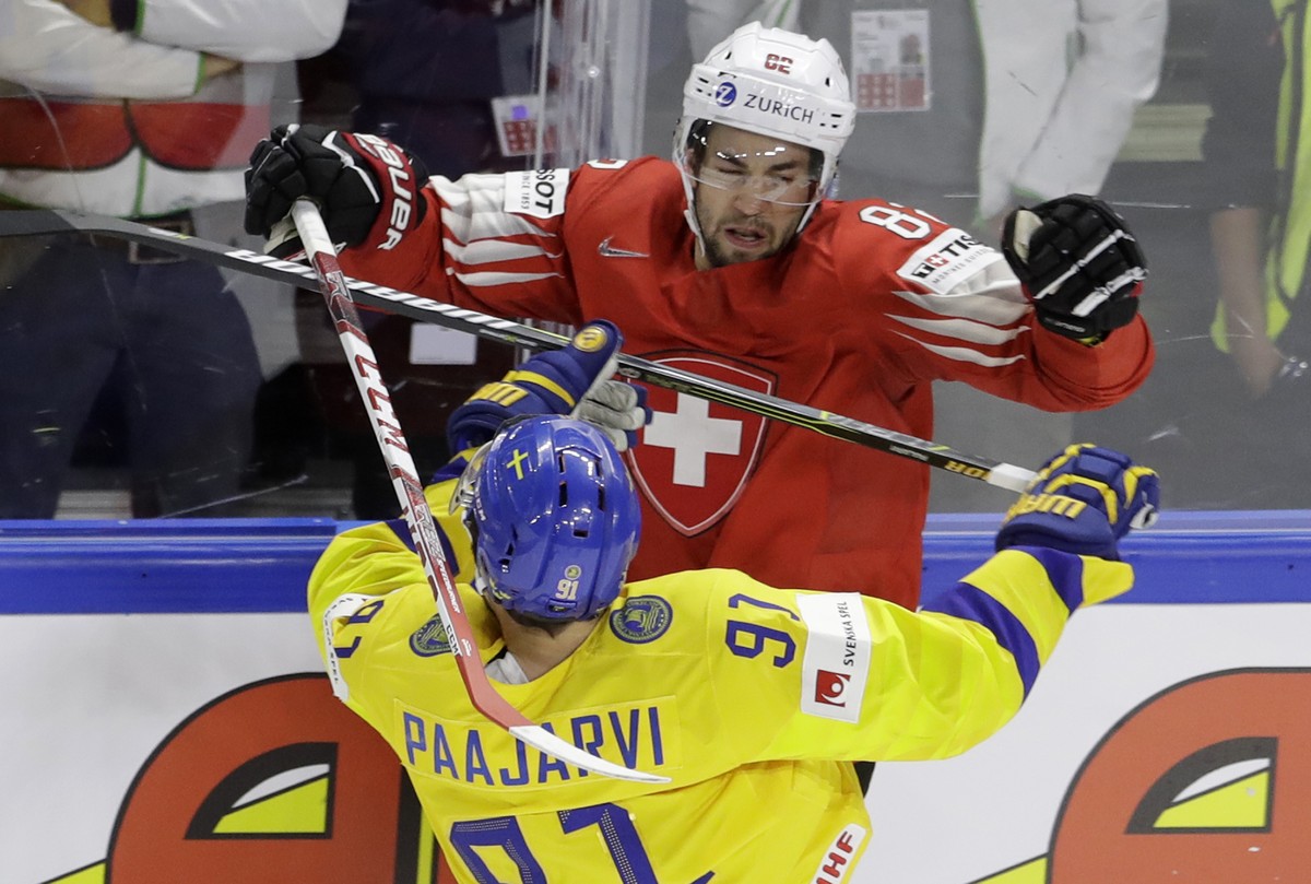 Switzerland's Simon Moser, above, challenges for the puck with Sweden's Magnus Paajarvi during the Ice Hockey World Championships final match between Sweden and Switzerland at the Royal aren ...