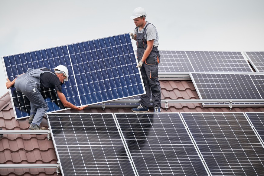 Fotovoltaik-Solarmodule werden auf einem Hausdach montiert.