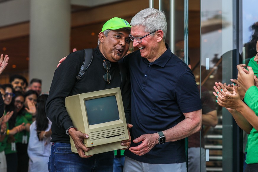 epa10578122 Apple���s chief executive officer (CEO) Tim Cook, welcomes consumers at the opening of the first Apple shop in Mumbai, India, 18 April 2023. Tim Cook, CEO of Apple, and Deirdre O&#039;Brie ...