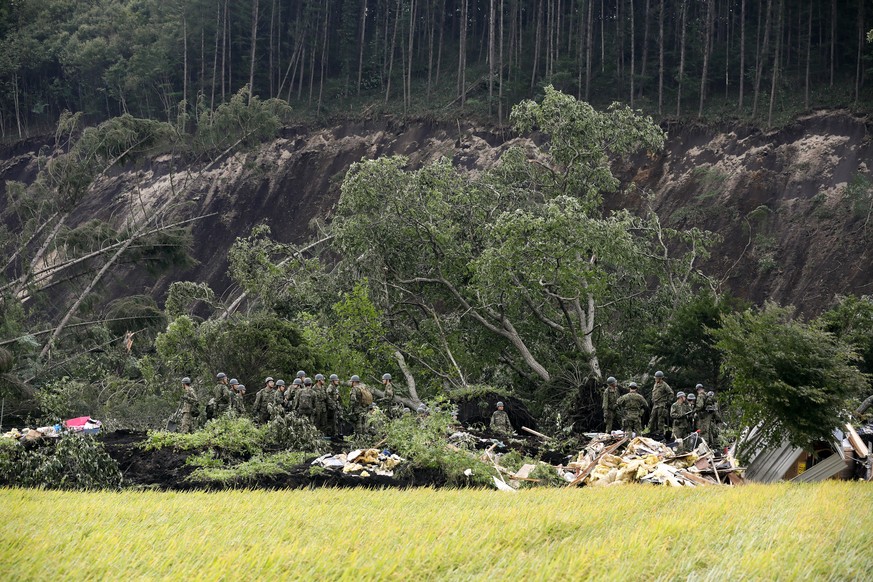 epa07002308 Japan&#039;s Ground Self-Defense Force&#039;s personnel give instructions for a rescue operation at a house destroyed by a large landslide caused by a powerful earthquake in Atsuma, Hokkai ...