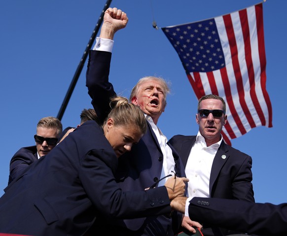 Republican presidential candidate former President Donald Trump is surrounded by U.S. Secret Service agents at a campaign rally, Saturday, July 13, 2024, in Butler, Pa. (AP Photo/Evan Vucci)