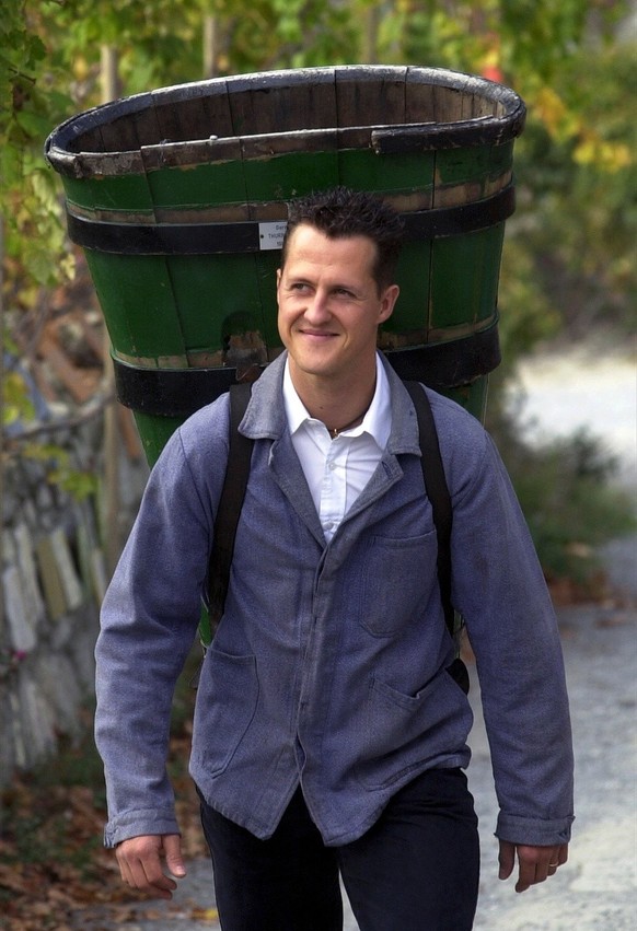 Wearing a bin for harvesting vines, German Formula One world champion Michael Schumacher walks through the &#039;Vigne a Farinet&#039;, the world&#039;s smallest vineyard owned by the Dalai Lama, in S ...