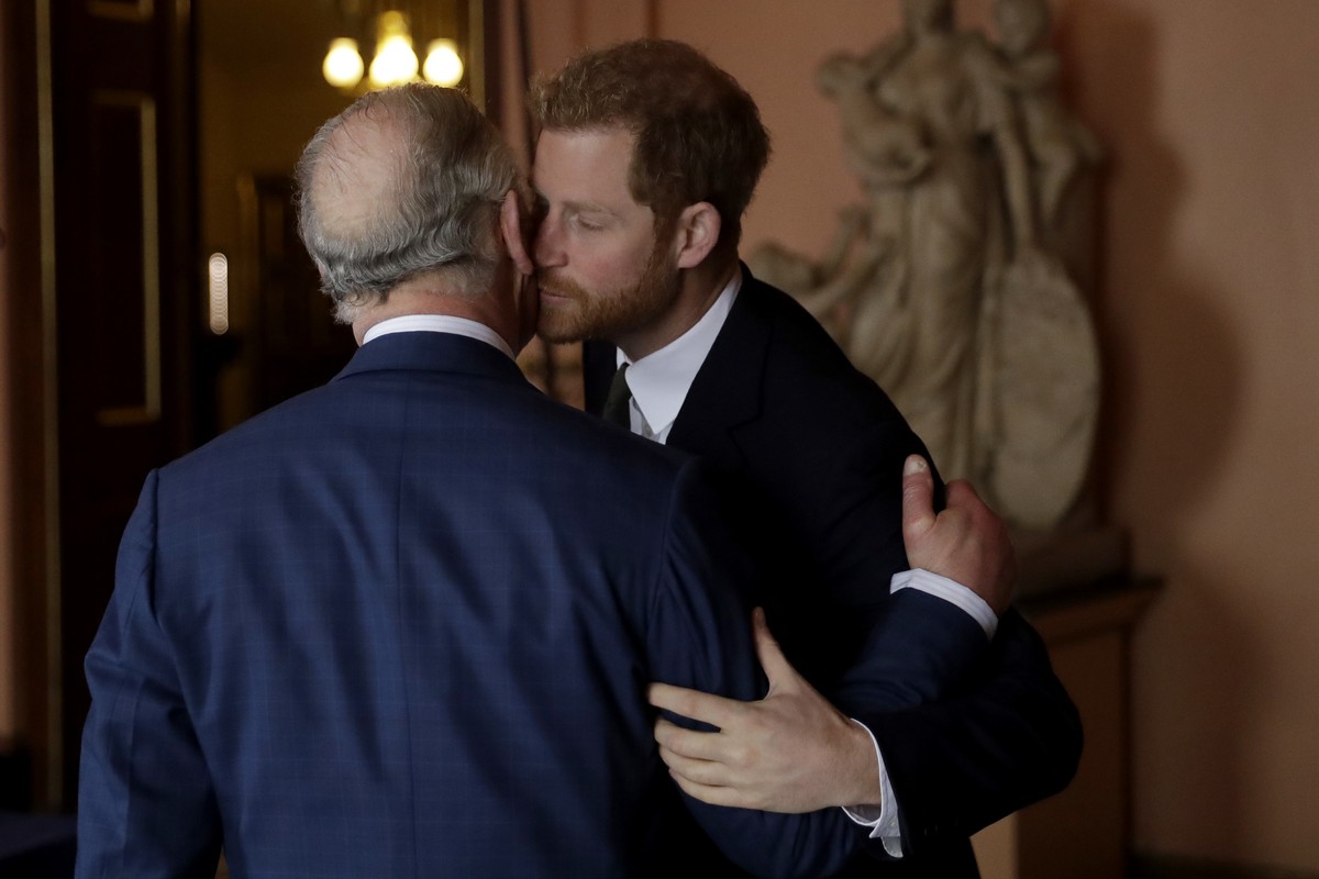 Britain's Prince Harry kisses and greets his father Prince Charles upon their separate arrival to attend a coral reef health and resilience meeting with speeches and a reception with delegates at ...