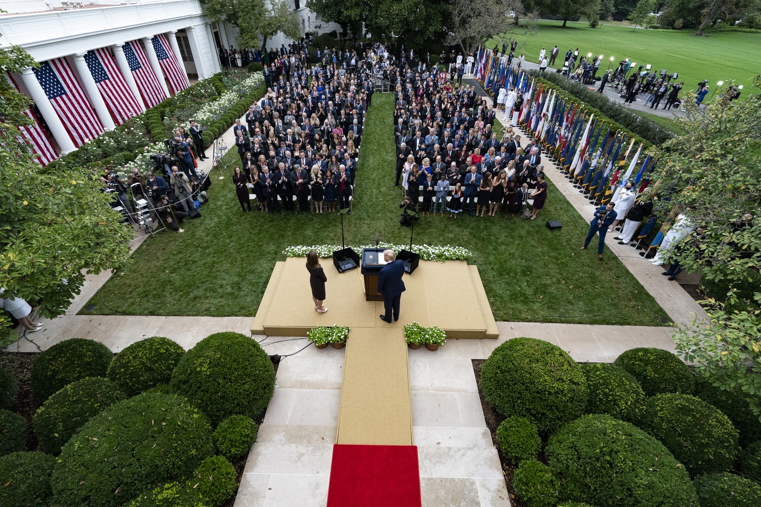 In this Sept. 26, 2020, photo President Donald Trump, center, stands with Judge Amy Coney Barrett as they arrive for a news conference to announce Barrett as his nominee to the Supreme Court, in the R ...