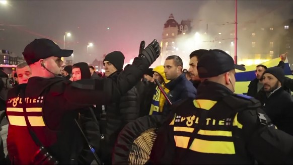 In this image taken from video, police escort Maccabi Tel Aviv supporters to the metro station leading them to the Ajax stadium, after pro-Palestinian supporters marched near the stadium, in Amsterdam ...