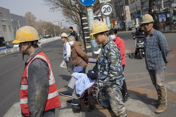 epa11227435 Construction workers wait to cross a street in Beijing, China, 18 March 2024. The surveyed urban unemployment rate in China stood at 5.3 percent in the first two months of 2024, according  ...