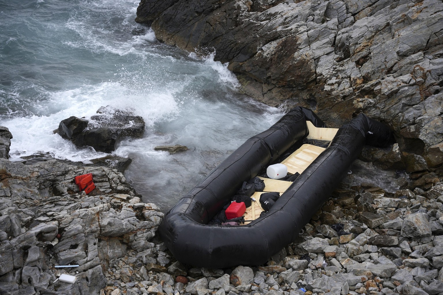 FILE - A dinghy lies on the shore after a shipwreck where two migrants were killed and eight were rescued, in Thermi, on the northeastern Aegean Sea island of Lesbos, Greece, on Wednesday, Jan. 10, 20 ...