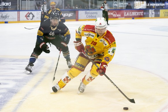 Gotterons Matthias Rossi, links, und Biels Jesper Olofsson, rechts, kaempfen um den Puck, beim Eishockey Meisterschaftsspiel der National League A zwischen den HC Fribourg Gotteron und dem EHC Biel-Bi ...