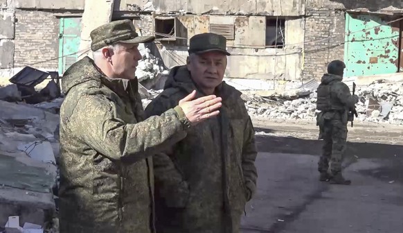 epa10502185 A still image from a handout video provided by the Press Office of the Russian Ministry of Defense shows Russian Defense Minister Sergei Shoigu (C) and commander of the Russian EA...