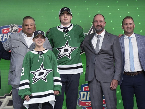 Lian Bichsel poses with Dallas Stars officials after being selected during the first round of the NHL hockey draft in Montreal on Thursday, July 7, 2022. (Ryan Remiorz/The Canadian Press via AP)