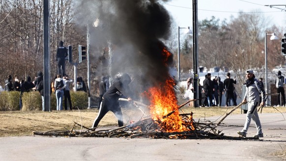 People burn branches to block a road during a riot in Norrkoping, Sweden, Sunday, April 17, 2022. Unrest has broken out in southern Sweden despite police moving a rally by an anti-Islam far-right grou ...