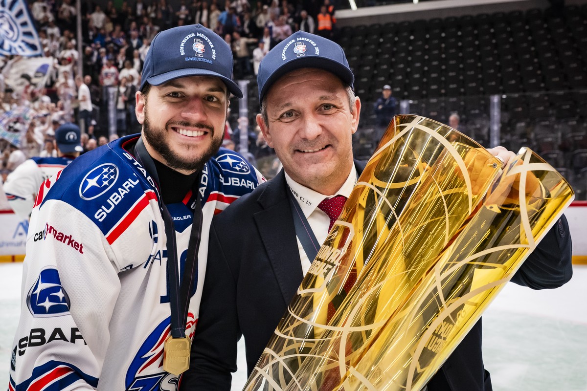 Sven Andrighetto (ZSC) and ZSC Lions' Head coach Marco Bayer celebrate with the trophy of Swiss Champion after winning by 2:3 during the fifth leg of the National League Swiss Championship final  ...