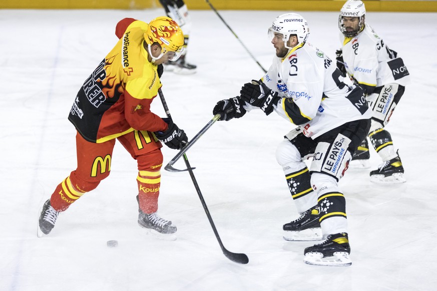 Le Top Scorer valaisan Guillaume Asselin, gauche, lutte pour le puck avec le defenseur jurassien Anthony Rouiller, droite, lors du match a huis clos du championnat suisse de hockey sur glace de Swiss  ...