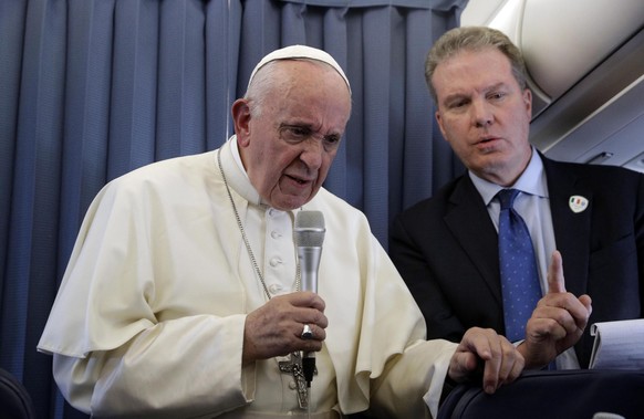 epa06975487 Pope Francis (L), flanked by Vatican spokesperson Greg Burke (R), listens to a journalist&#039;s question during a press conference aboard the flight to Rome at the end of his two-day visi ...