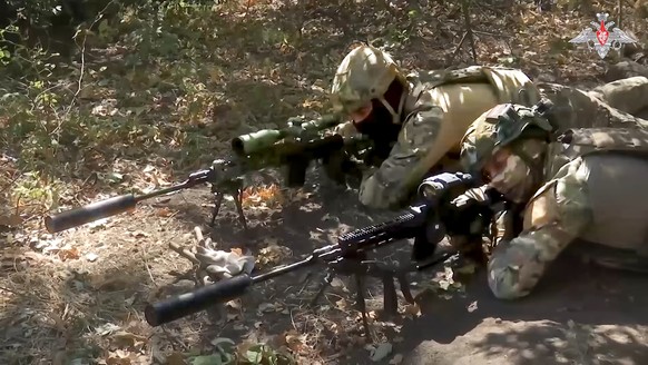 In this image made from video released by the Russian Defense Ministry on Wednesday, Oct. 2, 2024, Russian snipers, in an undisclosed location, fire towards Ukrainian forces. (Russian Defense Ministry ...