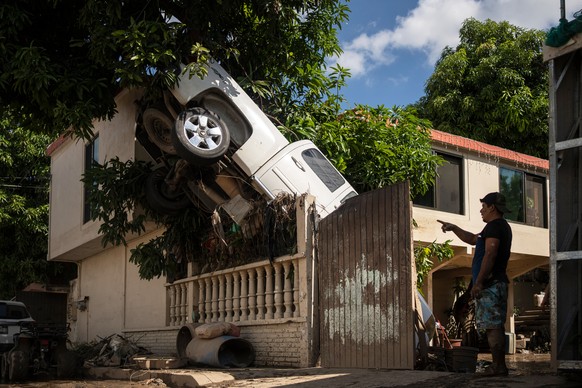 A pickup truck hangs over a fence in Poza Rica, Veracruz state, Mexico, Sunday, Oct. 12, 2025, after rain and flooding. (AP Photo/Felix Marquez)
APTOPIX Mexico Extreme Weather