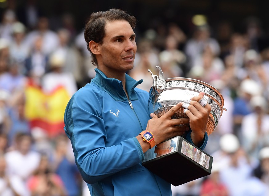 epa06799191 Rafael Nadal of Spain celebrates with the trophy after winning his 11th French Open title against Dominic Thiem of Austria during their men’s final match during the French Open tennis tour ...