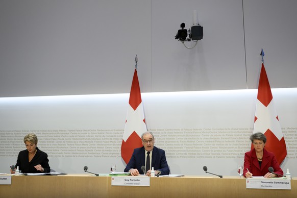 Bundesrat Guy Parmelin, Mitte, spricht an der Seite von Bundesraetin Karin Keller-Sutter, links, und Bundesraetin Simonetta Sommaruga, rechts, an einer Medienkonferenz ueber die Ukraine Krise, am Frei ...