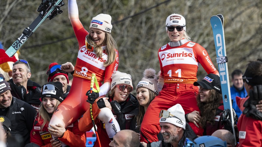Lara Gut-Behrami of Switzerland, as the winner, right, and her teammate Jasmine Flury, left, as second ex aequo, are carried by their teammates, bottom with from left, Delia Durrer, Michelle Gisin, Pr ...