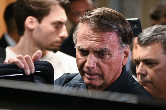 epa12259777 Former Brazilian President Jair Bolsonaro (C), leaves the headquarters of the Liberal Party in Brasilia, Brazil, 24 July 2025. Restrictions on Bolsonaro were ordered as part of a new inves ...