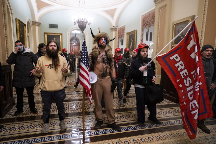 epa08923457 Supporters of US President Donald J. Trump stand by the door to the Senate chambers after they breached the US Capitol security in Washington, DC, USA, 06 January 2021. Protesters stormed  ...