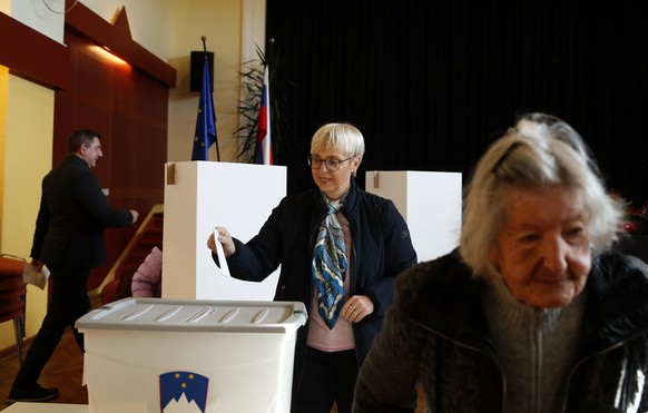 epa12543887 Slovenian President Natasa Pirc -Musar (C) votes during a referendum on a law legalizing assisted dying in Ljubljana, Slovenia, 23 November 2025. Slovenia is holding a binding referendum t ...