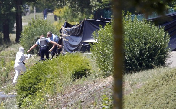 French crime scene investigators and Gendarmes are seen at work next to a black plastic sheet outside a gas company site at the industrial area of Saint-Quentin-Fallavier, near Lyon, France, June 26,  ...