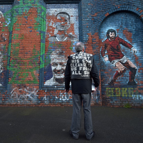BELFAST, NORTHERN IRELAND - MARCH 29: John Dumigan hands out religious tracts against the backdrop of a George Best mural as the Evangelical Protestant Society hold a protest against football on a Sun ...