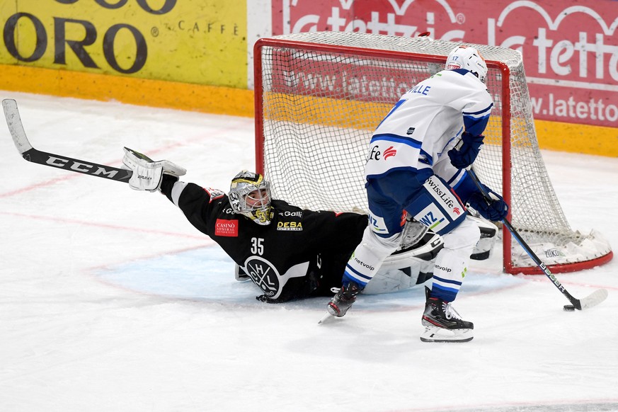 Lugano&#039;s goalkeeper Davide Fadani, left, fights for the puck with ZSC&#039;s player John Quenneville, right, during the preliminary round game of the National League 2020/21 between HC Lugano aga ...