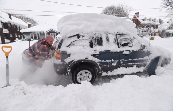 Kevin Deiner of Erie, Pa., pushes his Ford Escape out of the deep snow on West Sixth Street Saturday, Dec. 30, 2017. Forecasters say 1 to 3 inches of snow could fall in most areas before the precipita ...