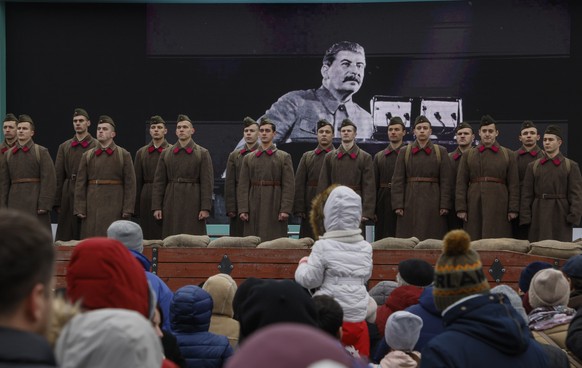 epa10287914 A Russian choir with its members dressed as Soviet-era soldiers perform in front of a picture of Joseph Vissarionovich Stalin (background) during an exhibition dedicated to the &#039;Russi ...
