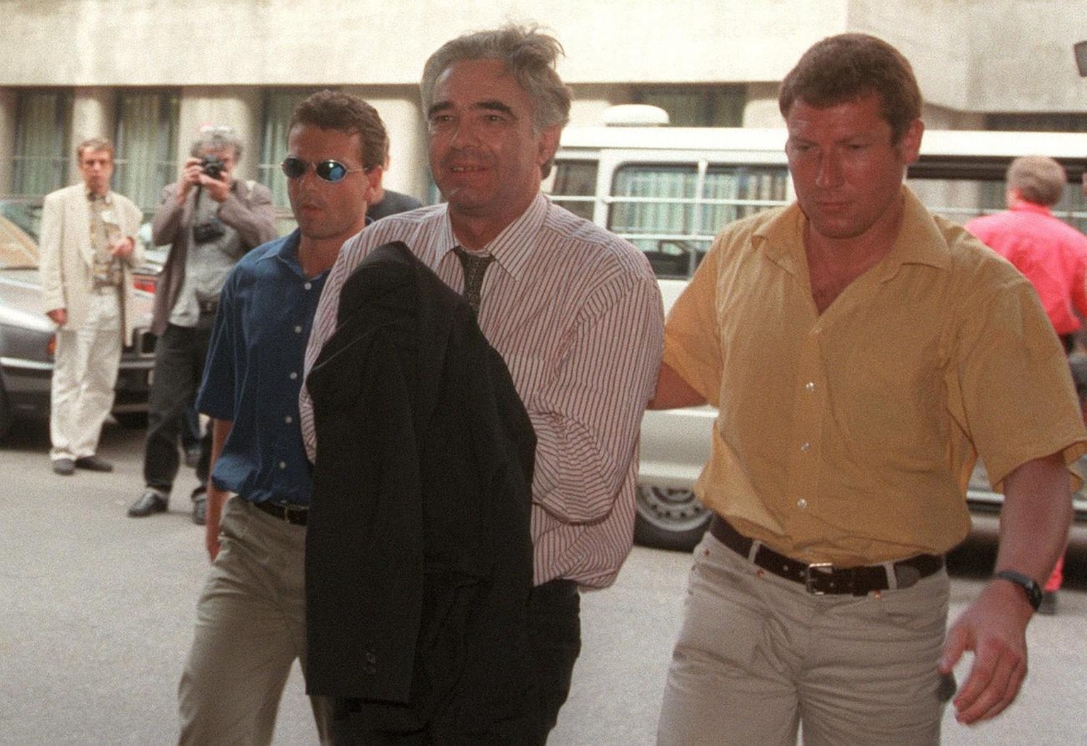 Ein gezeichneter Werner K. Rey (Mitte) wird am 2. Juni 1998 von zwei Polizisten in Zivil ins Berner Amthaus gebracht.