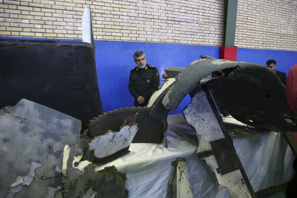 Head of the Revolutionary Guard&#039;s aerospace division Gen. Amir Ali Hajizadeh looks at debris from what the division describes as the U.S. drone which was shot down on Thursday, in Tehran, Iran, F ...