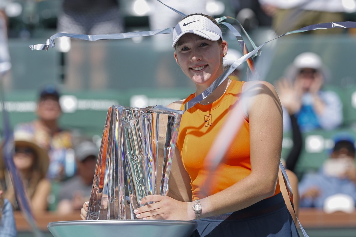 epa11969165 Mirra Andreeva of Russia poses with her championship trophy as streamers are shot out after winning the women's singles final match of the BNP Paribas Open tennis tournament in Indian ...
