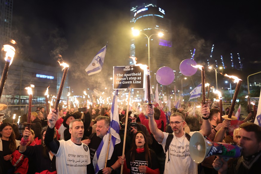 epa10421188 People light torches and take part in a protest against the new government in Tel Aviv, Israel, 21 January 2023. A statement made by the country&#039;s new Justice Minister Levin declaring ...